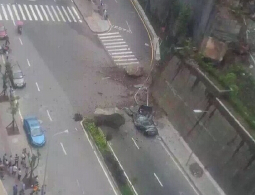 轿车被巨石砸成饼 万州江南新区山上巨石滚落（图）