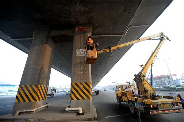 济南高架桥下清理野广告条幅近百个 张贴容易清除难