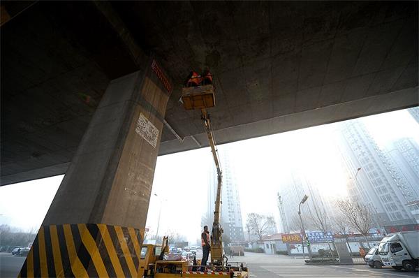 济南高架桥下清理野广告条幅近百个 张贴容易清除难