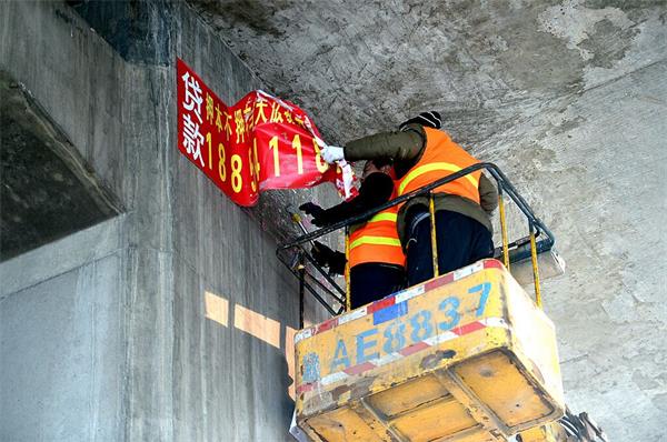 济南高架桥下清理野广告条幅近百个 张贴容易清除难