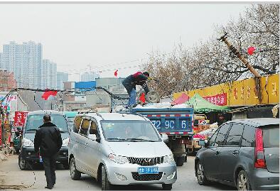 济南七贤配货市场马路边线缆垂落一周 车辆经过靠“托举”