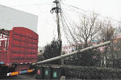 济南七贤配货市场马路边线缆垂落一周 车辆经过靠“托举”