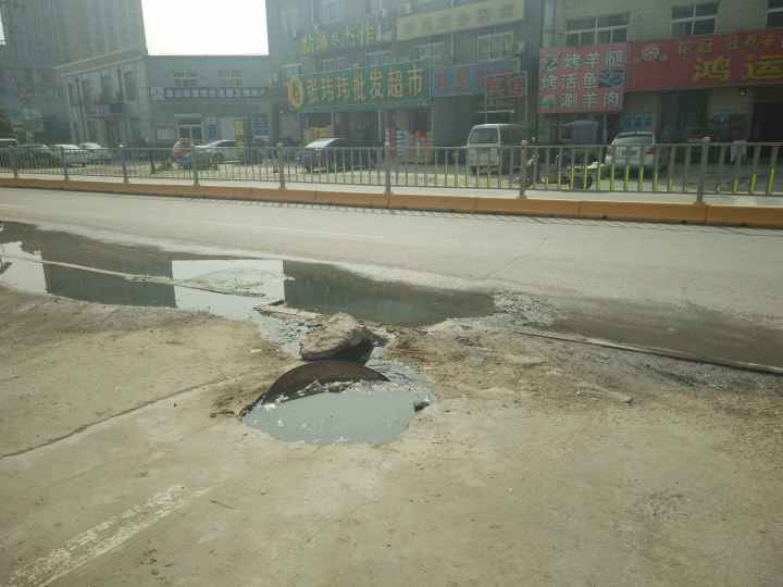 济兖路一井盖丢失污水外溢半年 商户盖铁皮自费抽臭水