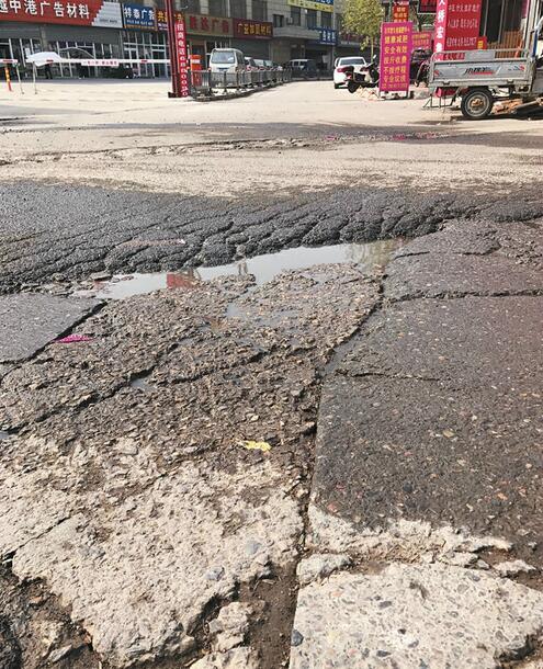 金阁花园小区门口路面坑洼不平 居民出入常被“坑”