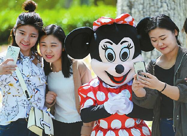 济南一七旬老太扮米老鼠为儿媳妇筹救命钱 游客纷纷与其合影捐款