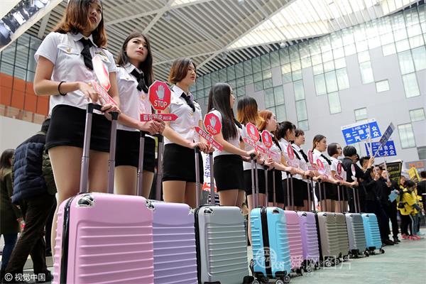 山东东营:“空姐”着短裙组团现身车展 手推拉杆箱四处促销