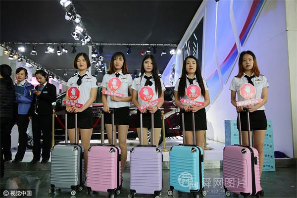 山东东营:“空姐”着短裙组团现身车展 手推拉杆箱四处促销