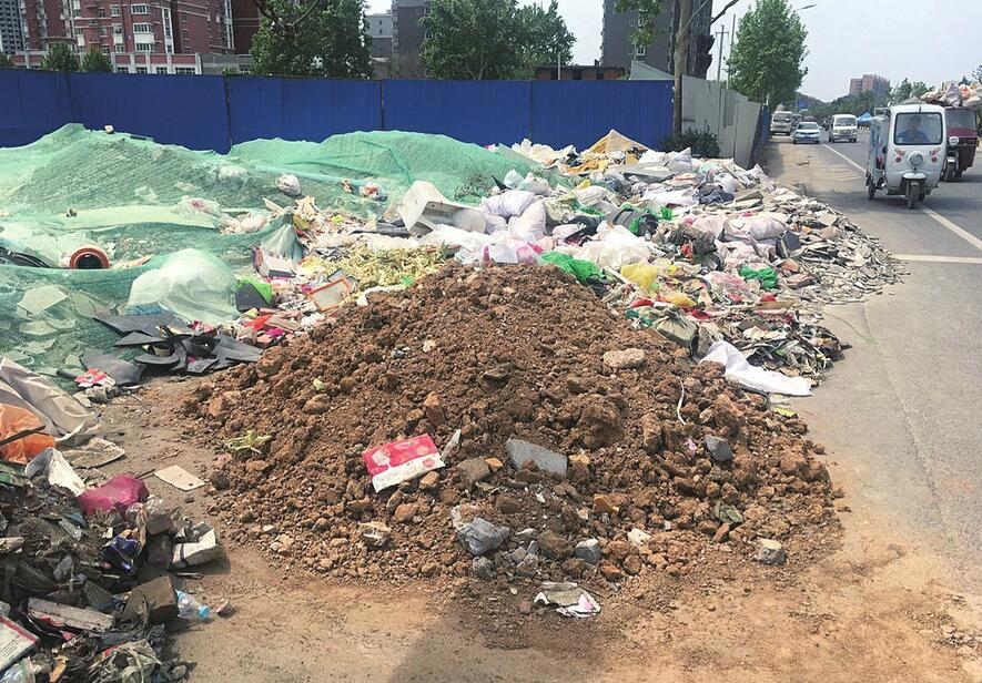 海晏门街附近路段生活垃圾裸露 建筑垃圾周围污水臭气熏天