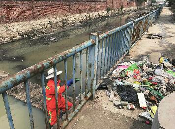 九曲沟河道内垃圾遍布气味刺鼻 污水颜色已浑浊发黑