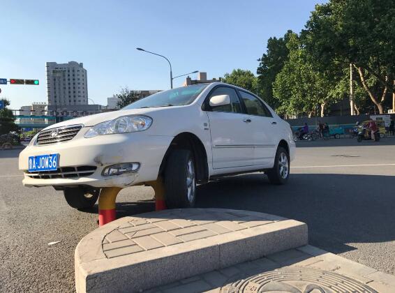 济南女司机驾车转弯撞上U形隔离柱 悬在半空中动弹不得