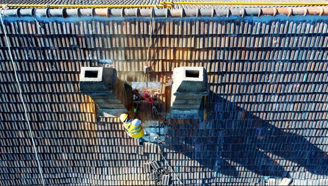 防止雨季渗漏！济南数名工人“飞檐走壁”修缮百年火车站 