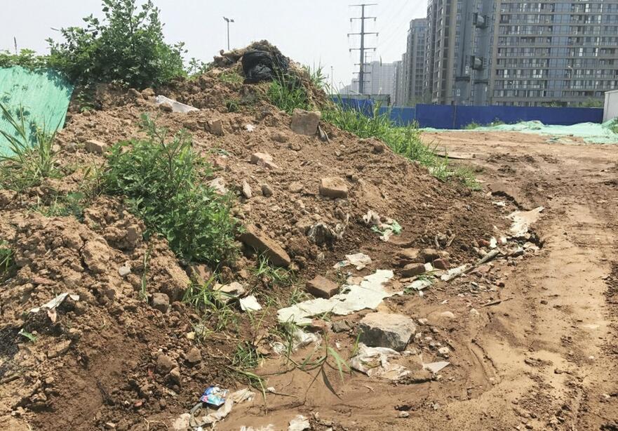 绿网防尘半遮面！济南绿城百合花园北侧建筑垃圾裸露 