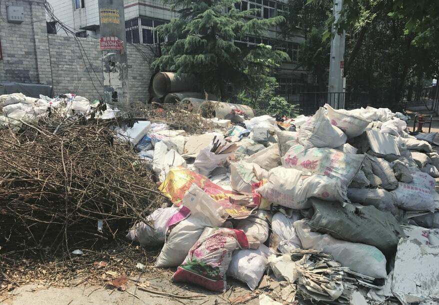 济南工业南路西段楼下平地起沙包 生活垃圾“裸奔”
