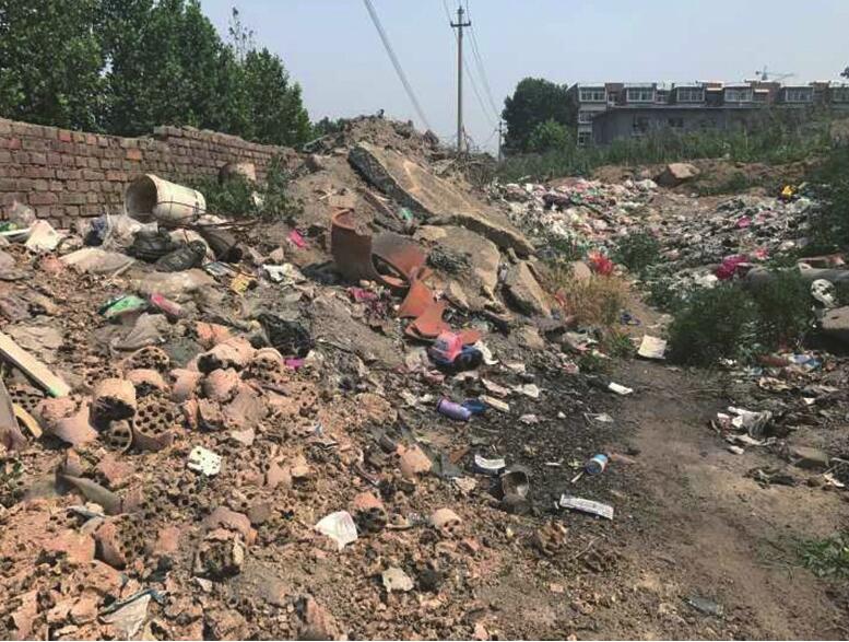 烈士山东路公交站牌北侧建筑垃圾裸露 已存放3个月之久