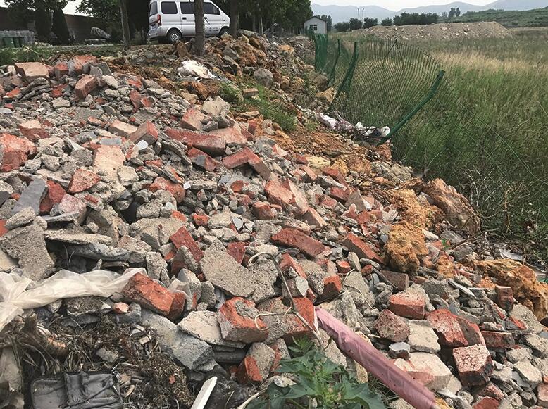 傅家东公交站牌附近建筑垃圾仍在裸露 附近扬尘明显