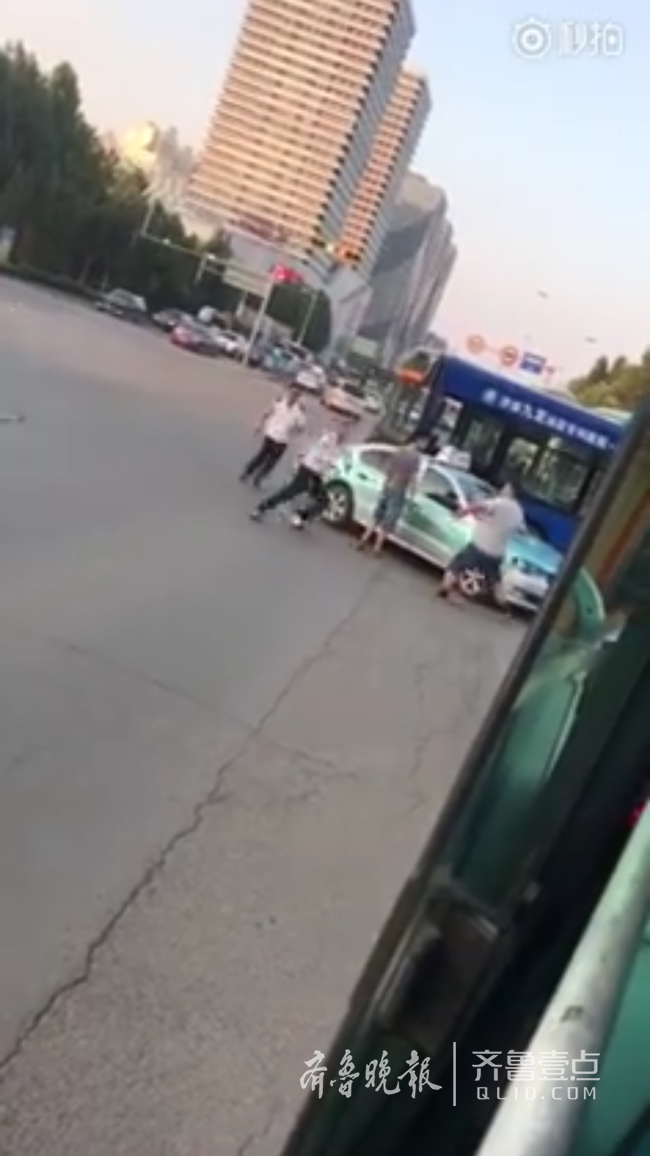 疑因被出租车撞 济南123路公交司机持木棍在街头动手