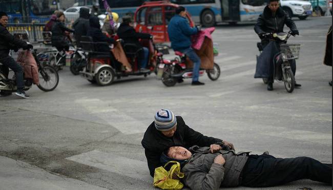 过往市民上前询问是否需要帮助,老人说躺在地上的是他的儿子,因坐车时间太长有点晕,躺在地上休息一会,拒绝了市民的帮助。就这样,老人支撑着男子的头部,静静的等待儿子醒来。