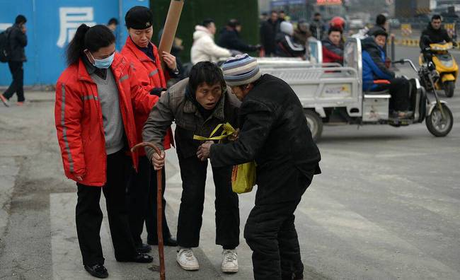 这时两位市民赶紧上前,将男子搀扶起来,老人一手拄着拐杖,另一手搀着男子,母子俩佝偻着腰一步一挪的离开。
