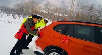 娶亲路难行：交警帮新郎推车 新郎身披红色被面卖力推车