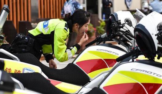 都市里的铁骑飞燕 女铁骑休息间隙对着摩托的后视镜涂抹唇膏