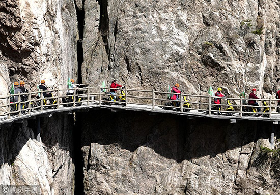 河南洛阳:50名环保志愿者挑战绝壁栈道 呼吁低碳出行