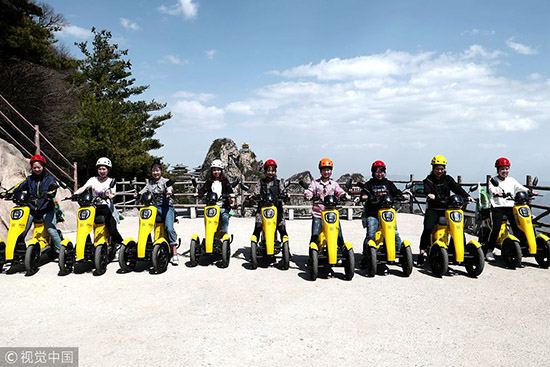 河南洛阳:50名环保志愿者挑战绝壁栈道 呼吁低碳出行