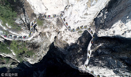 河南洛阳:50名环保志愿者挑战绝壁栈道 呼吁低碳出行