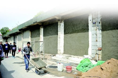 11日,山师北门对面20余间商铺正在进行封堵门窗。　本报记者　王媛　摄