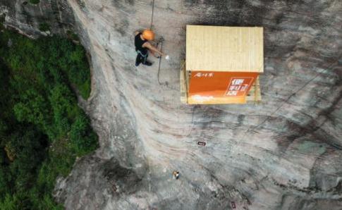 无奇不有！小卖部开悬崖上 悬空于100余米高度的买卖是怎么完成的？