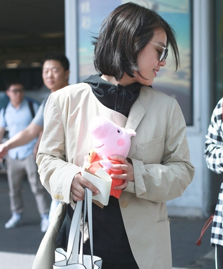 马思纯机场获小猪佩奇爱不释手 黑色运动帽衫外搭不对称外套气色大好
