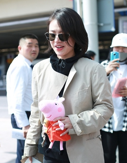 马思纯机场获小猪佩奇爱不释手 黑色运动帽衫外搭不对称外套气色大好