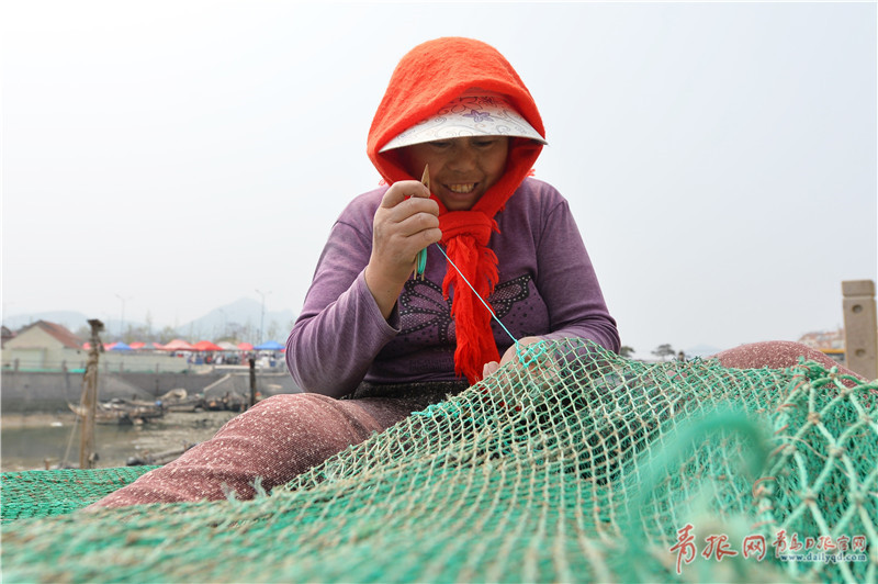 青岛码头实拍 渔民吊船补网修整进入休渔期