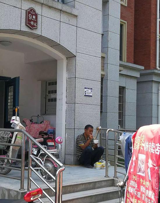 蹲墙角吃面照走红 皮肤黝黑的民警看起来就像一个普通的农民工