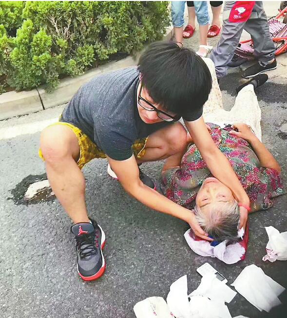 老太太路边摔倒头破血流 热心小伙跪地施救