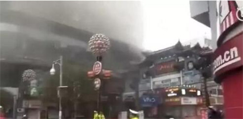 王府井建吸烟区:“烟客”完胜 醒目的地标旁横着13根吸烟的柱子 