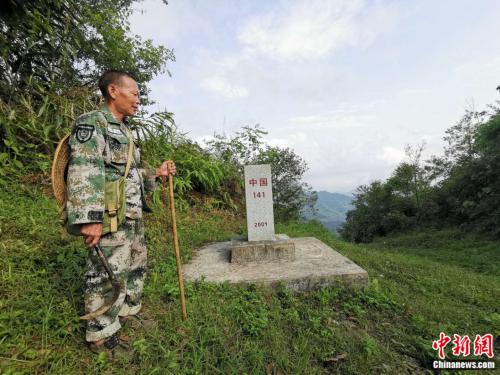 杨天才与界碑。张旭 摄
