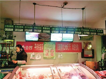 济南一农贸市场肉店贴出了降价的促销海报 新时报记者何涛 摄