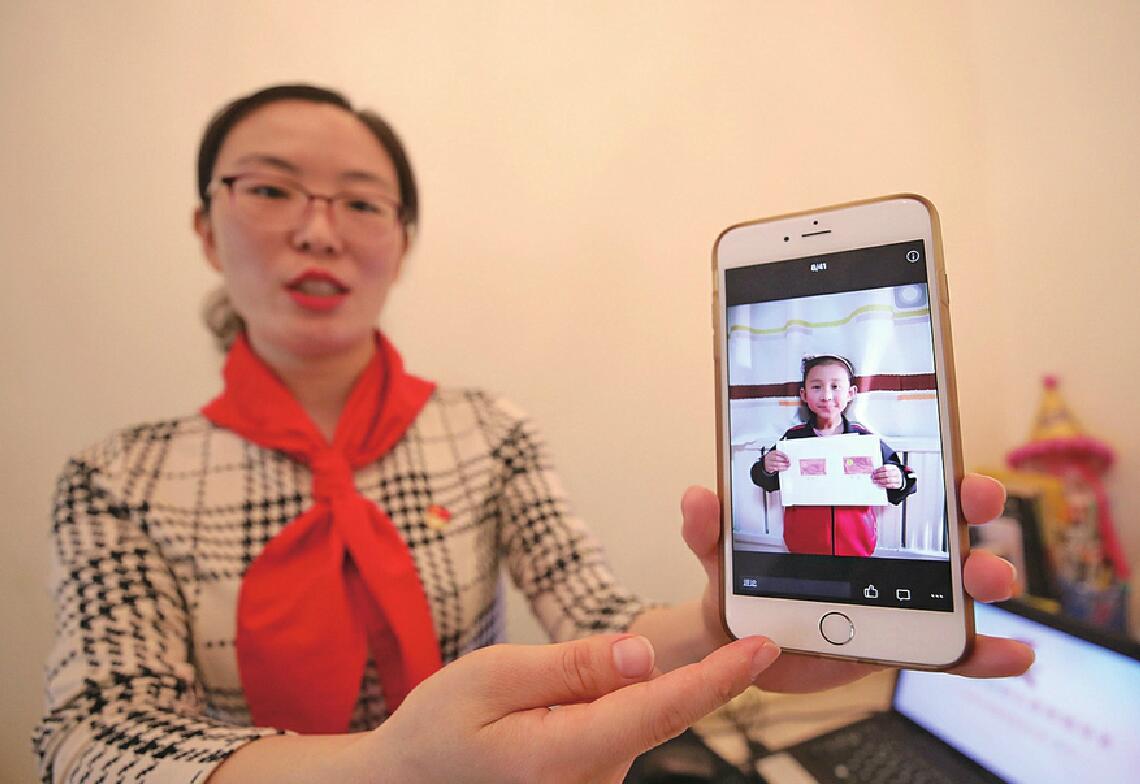 董妍展示学生画的党旗,团旗.