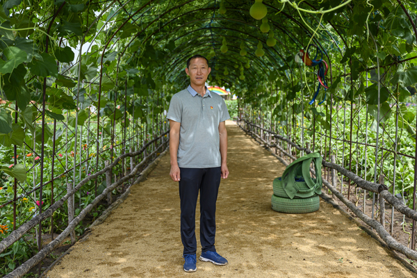 2020年8月，内蒙古兴安盟义勒力特嘎查，义勒力特嘎查党支部书记白双龙站在“开心果园”的葫芦藤下。