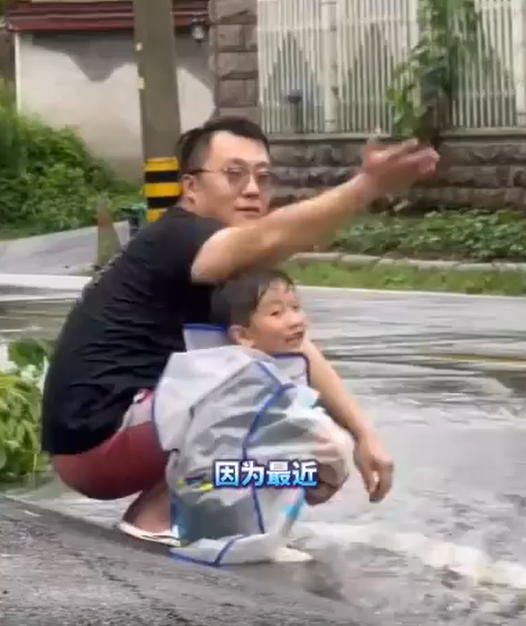 爸爸带娃穿雨衣路边求溅水,司机很配合孩子玩得很开心