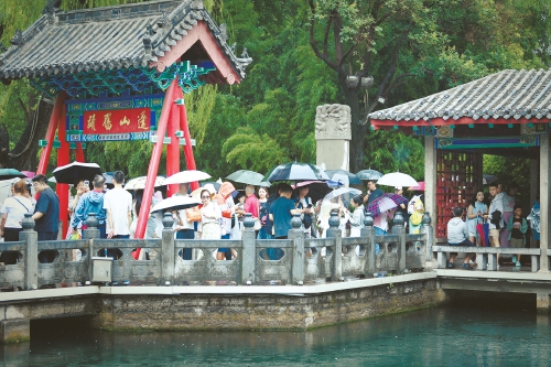 济南细雨绵绵，游客雨中赏泉，别有一番情趣
