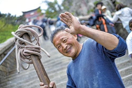 扁担上的泰山：当“挑山工”遇见“机器狗”，山脊上的传承与变革