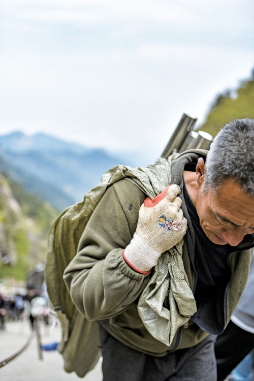 扁担上的泰山：当“挑山工”遇见“机器狗”，山脊上的传承与变革