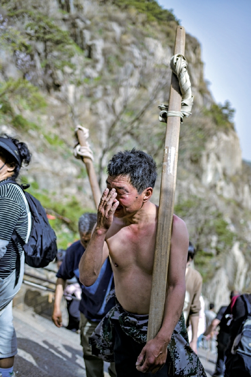扁担上的泰山：当“挑山工”遇见“机器狗”，山脊上的传承与变革